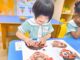 Happy child at Ichiban Nurtureland engaging in early intervention activity using expressive face puzzle